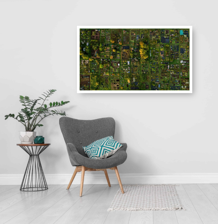 A high-resolution aerial photograph of a large allotment garden, showing a patchwork of individual plots with plants, pathways, sheds and greenery arranged in irregular grid-like rows.